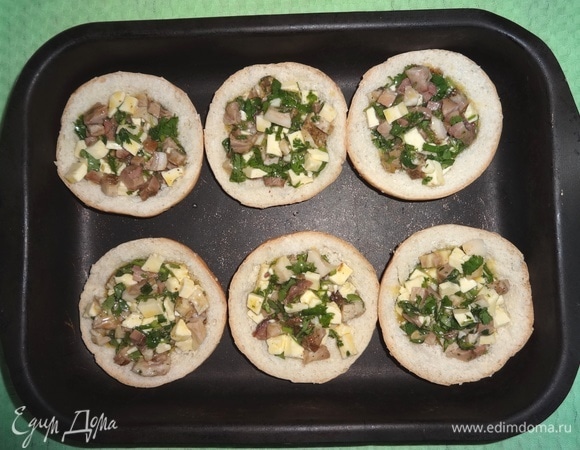 Половинки булочек положить в форму и выложить в них начинку.