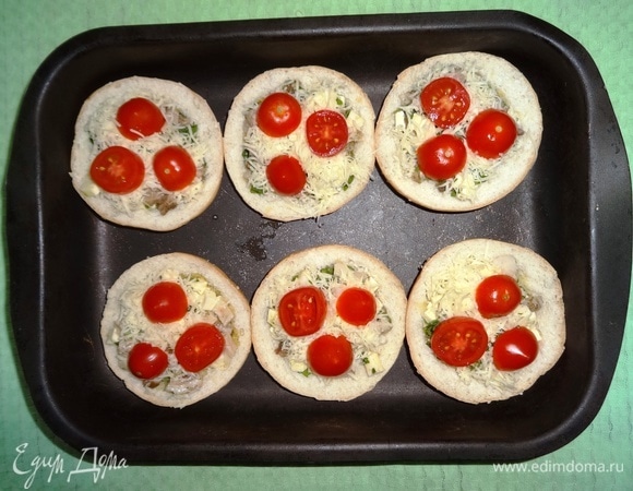 На сыр выложить кружки черри. Поставить форму с закуской в духовку, разогретую до 180°C, на 5–7 минут.
