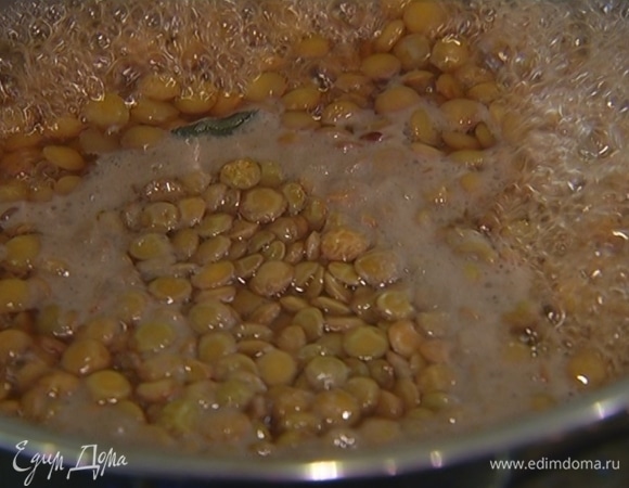 Чечевицу залить водой согласно инструкции на упаковке, добавить помидор целиком, очищенный зубчик чеснока, лавровый лист и варить до готовности.