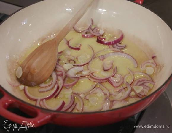 Разогреть в сковороде с жаропрочной ручкой оливковое масло и обжарить лук и чеснок.