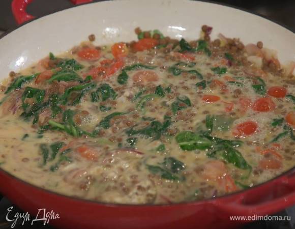 Отваренную чечевицу добавить в сковороду, посолить, поперчить и перемешать, затем влить яичную массу и еще раз слегка перемешать.