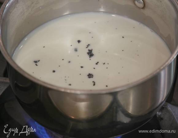 Приготовить крем: молоко влить в кастрюлю, добавить зерна ванили и прогревать на небольшом огне до появления первых пузырьков.