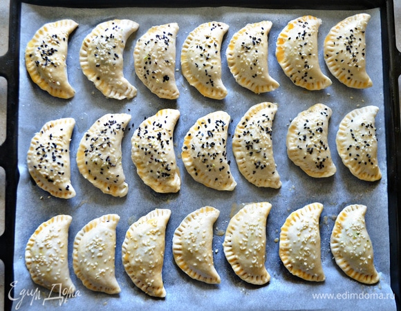 С помощью кисточки смажьте поверхность пирожков взбитым яйцом и посыпьте кунжутом.