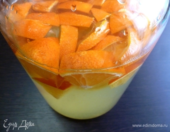 Сложить кусочки апельсина в банку с теплой кипяченой водой. Всыпать сахар, лимонную кислоту и дрожжи. Оставить банку в теплом месте для брожения на сутки. У меня банка стояла на кухне на плите. Горлышко прикрыть тканью.