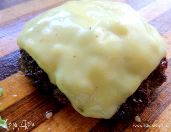 Готовую котлету перенести на доску. Жарим вторую часть фарша под сыром и бекон по желанию.