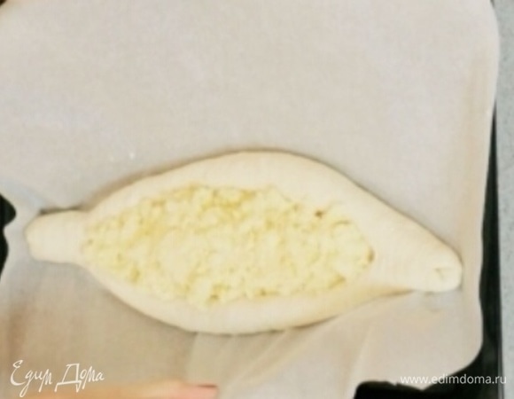 Готовое тесто разделить на три части, раскатать в овал и свернуть бортики так, чтобы получилась лодочка. Каждую лодочку наполнить начинкой и поставить в разогретую до 250°C духовку, выпекать 5–7 минут.