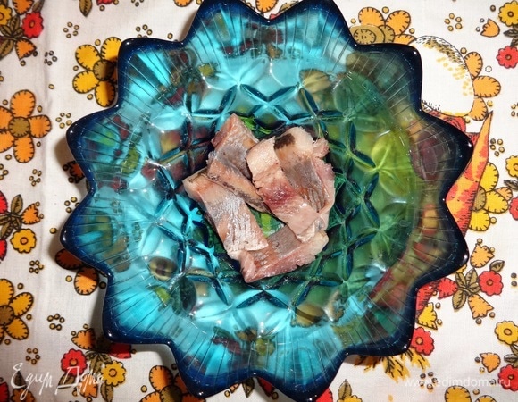 В миску выложить часть кусочков селедки.