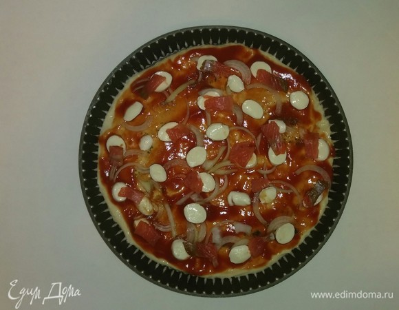 Затем выкладываем нарезанные шарики моцареллы и кусочки рыбы. Ставим форму с пиццей в разогретую до 200°C духовку на 20 минут (температура и время приготовления зависит от духовки). Приятного аппетита!