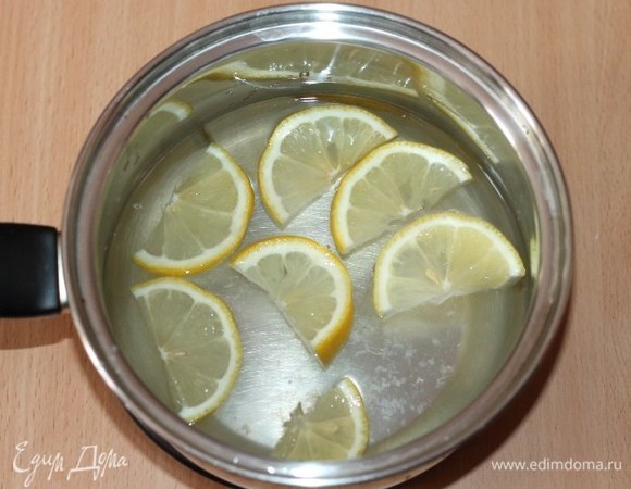 Из воды (1 литр) и сахара сварить сироп, постоянно помешивая. В кипящий сироп выложить дольки лимона и снять с огня.