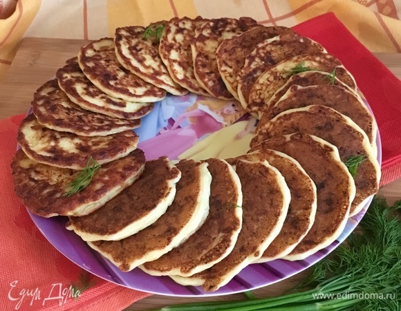 Выложить оладьи на блюдо по кругу, оставив серединку для соусника.