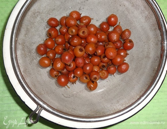 Отвар боярышника с ягодами процедить через мелкое сито. Отвар вернуть обратно в кастрюлю и поставить на небольшой огонь.