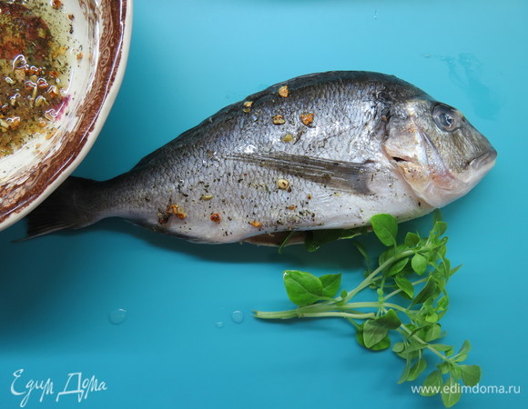 У рыбы удалить жабры и внутренности из брюшка, натереть полученным маринадом снаружи и внутри. В брюшко вложить дольку лайма и веточку базилика. Оставить на полчаса.