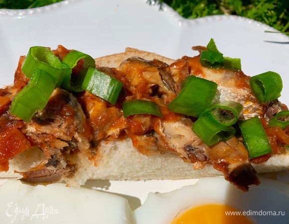 Кладу кильку на хлеб, сверху посыпаю нарезанным зеленым луком.