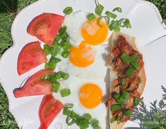 Жарю яйца на оливковом масле, выкладываю на тарелку, также кладу хлеб с килькой и пару долек помидора. Я не солю, при желании вы добавляйте соль по вкусу.