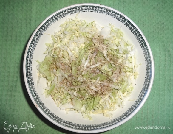 В миску сложить нарезанные капусту и чеснок, посолить, поперчить. Продукты перемешать, слегка помяв руками.