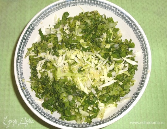 Нарезанную зелень положить в чашку с капустой, перемешать.