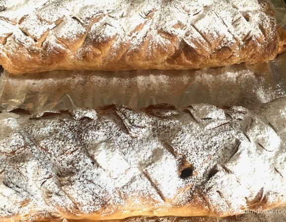 У меня готовое покупное слоеное тесто, разморозить. Разрезаю на две части, щедро мажу маком и кладу яблоки и изюм. Заворачиваю в рулет. С верху делаю надрезы. В духовку при 180°C на 30 минут. По готовности вынуть, посыпать корицей, сахарной пудрой.