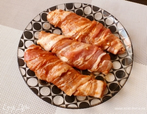 Обмотать каждый куриный кусочек полоской бекона.