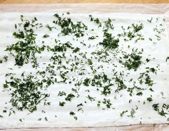 У меня длинный и тонкий лаваш, который я разделила на 3 части. Берем 1 часть лаваша (без дырочек) и смазываем сырной начинкой. Посыпаем укропом.