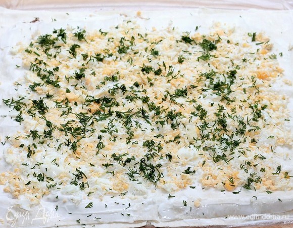 Накрываем 3 слоем лаваша, смазываем майонезом, кладем тертые яйца и посыпаем зеленью. Даем лавашу с начинкой немного отлежаться (минут 10) и пропитаться. Лаваш будет мягче, и его удобнее сворачивать в рулет.