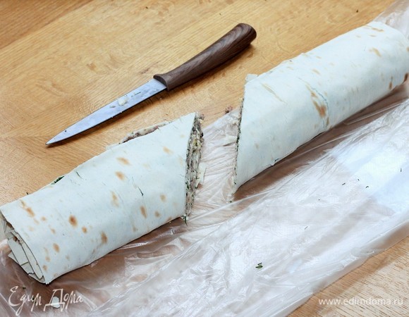 Чтобы удобнее было есть рулет, разрезаем его на 2 части и заворачиваем в пленку или кладем в пакетик для еды, убираем в холодильник на 2–3 часа.