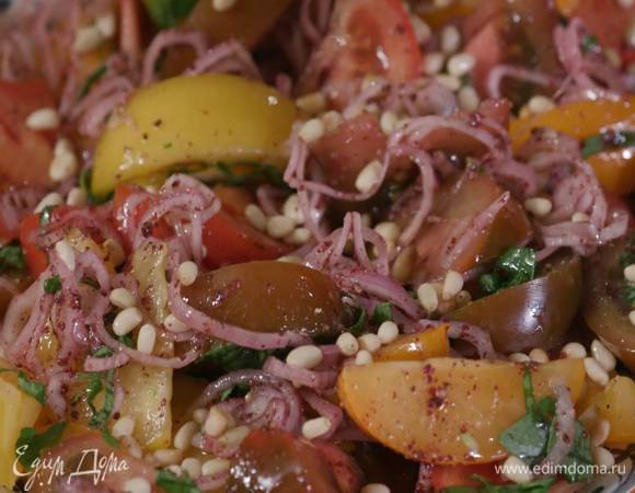 Помидоры посыпать нарезанным базиликом, полить оставшимся оливковым маслом, посолить, поперчить, сверху разложить лук со специями, посыпать салат кедровыми орехами.