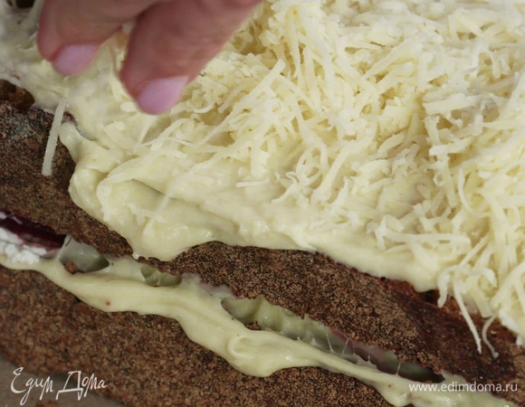 Вторым куском хлеба накрыть первый. Смазать сэндвич сверху бешамелем и посыпать оставшимся сыром. Убрать в духовку под гриль на 2 минуты.