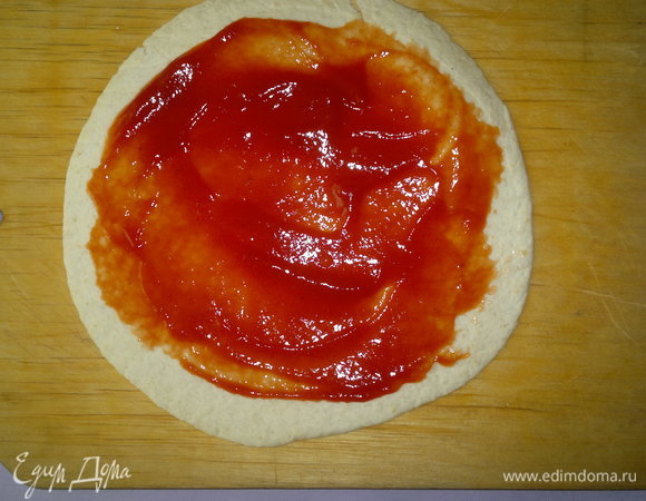 Тортилью смазать острым томатным соусом или кетчупом, не доходя немного до краев.