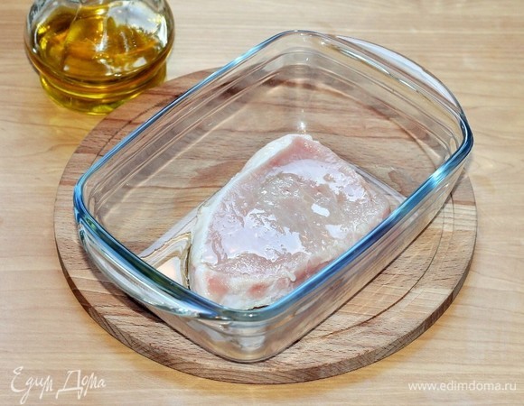 Нарезаем стейк толщиной 2 см. Я купила готовые свиные стейки из карбонада, и толщина их поменьше, но лучше не меньше 2 см. Замаринуем кусочек свинины. Кладем стейк в продолговатую посуду и поливаем растительным маслом (1 ст. л.). Масло для того, чтобы прилипали специи.