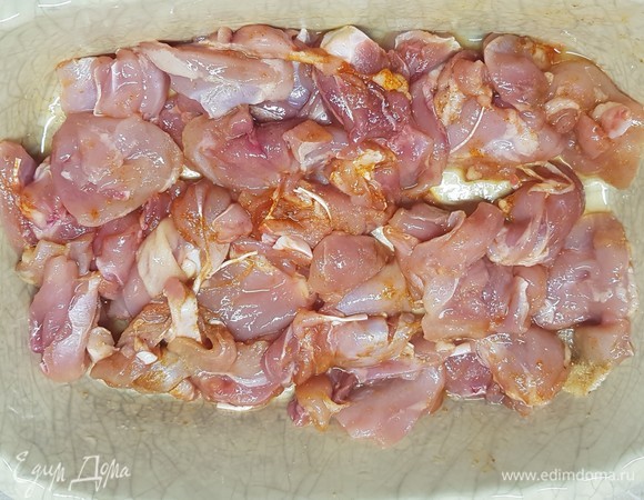 Мясо срезать с куриных бедер и нарезать небольшими кусочками. Посолить, добавить любимую приправу. Сложить в форму для запекания.