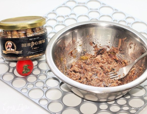 Со шпрот ТМ «Капитан Вкусов» слить масло, выложить их в миску, размять вилкой.
