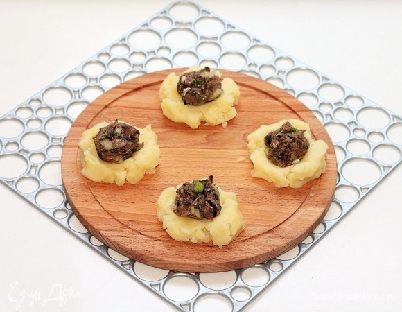 Каждый шарик аккуратно придавить и в центр выложить чайную ложку рыбной начинки.