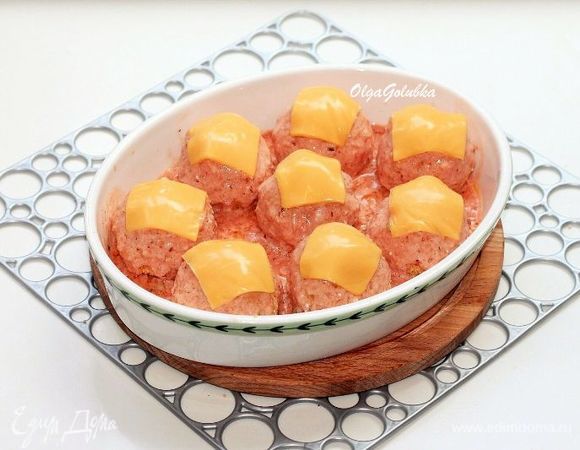 Разрезаем каждую пластину сыра на 4 части и закрываем сверху каждый шарик листиком (1/4 часть) сыра. Ставим форму в хорошо разогретую до 180°C духовку на среднюю полку и запекаем биточки до румяного цвета и расплавления сыра (минут 30).