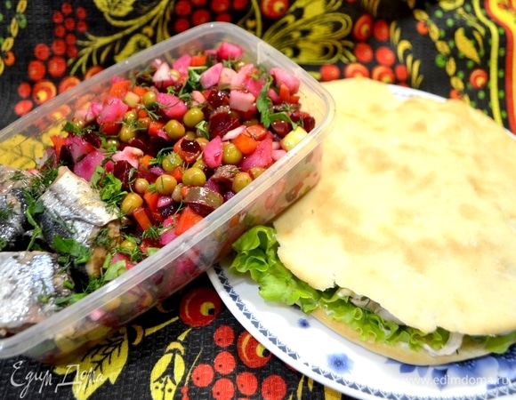 В контейнер положить винегрет, сверху — целые кусочки рыбы.