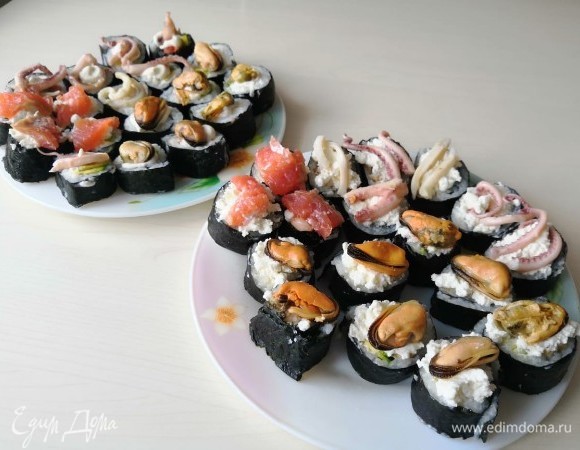 Сверху суши украсить тем, что находится внутри них: творожный сыр, мидии, кальмары и красная рыба.