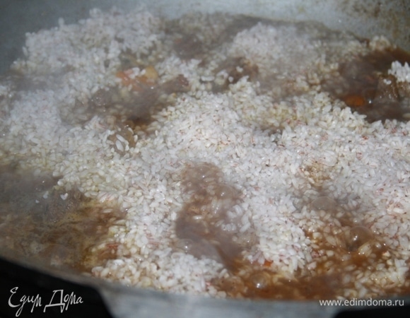 Всыпаем рис (рис у меня сорта «Самарканд», его нужно заранее замочить и промыть). Доливаем воды по стенке (примерно 0,5 л). Вода — кипяток! Иначе плов не будет рассыпчатым.