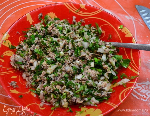 Приготовить тесто для пельменей. 2 яйца взбить, добавить соль, воды немного, перемешать и постепенно добавлять муку, помешивая (сколько возьмет муки). Вымесить тесто, дать отдохнуть. Приготовим начинку: открыть банку сайры ТМ «Капитан Вкусов», размять вилкой. В размельченную рыбу добавить мелко нарезанную зелень и перемешать.