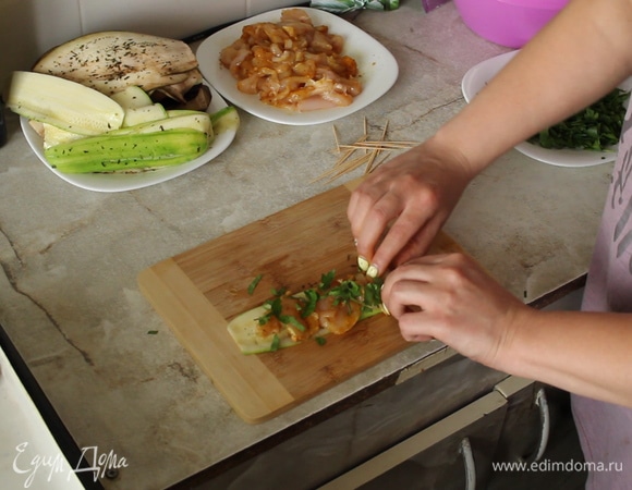 Формируем рулетики: на слайс кабачка или баклажана выкладываем мясо, посыпаем петрушкой, заворачиваем и кладем в форму.