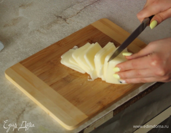 Нарезаем тонкими ломтиками сыр.