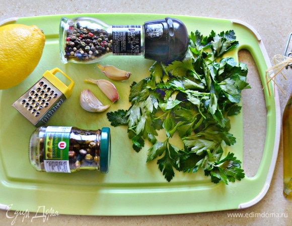 Для маринада отделите зелень петрушки и мелко порубите. Натрите на мелкой терке цедру лимона. Чеснок также натрите на терке либо выдавите с помощью чеснокодавилки. С каперсов слейте жидкость и мелко порубите. В миске смешайте все составляющие маринада, приправьте перцем, слегка посолите и добавьте 1 ст. л. оливкового масла. Все хорошо перемешайте.