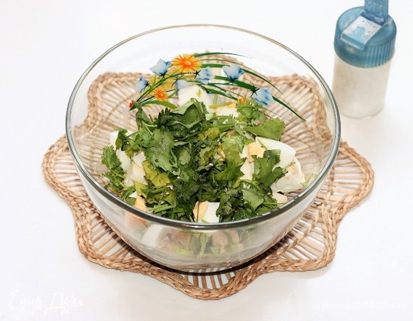 Кинзу вымыть, обсушить бумажным полотенцем и нарезать. Добавляем в миску сваренные вкрутую, очищенные и порубленные яйца, зелень, домашний майонез и кетчуп. Можно добавить прессованный зубчик чеснока (по желанию).