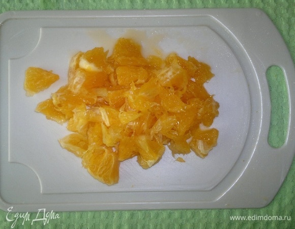 Один апельсин очистить от кожуры, нарезать кружками и разобрать на дольки, выбирая семена и отрезая грубые волокна.