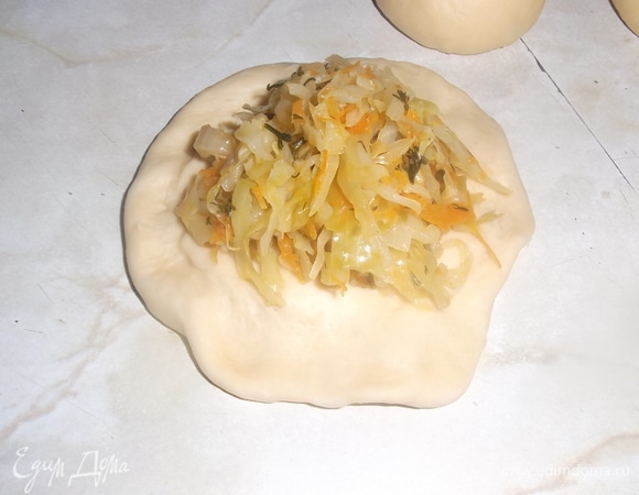 Из подошедшего теста сформировать шарики размером с куриное яйцо. Дать расстояться в течение 10 минут. Каждый шарик раскатать в лепешку, выложить на середину начинку. Края защипнуть.