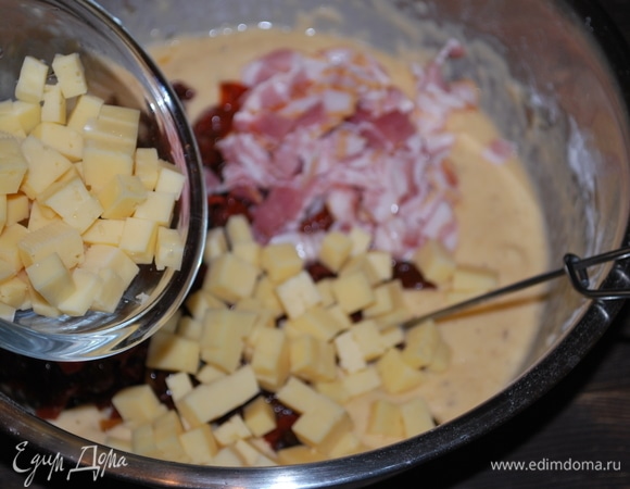 Добавьте нарезанный кусочками сыр, бекон и вяленые томаты. Если у вас масло не из под вяленых томатов, то добавьте в тесто свежий базилик, мелко его нарежьте. Я не добавляла — у меня ароматное масло из-под помидоров, в нем уже есть базилик.