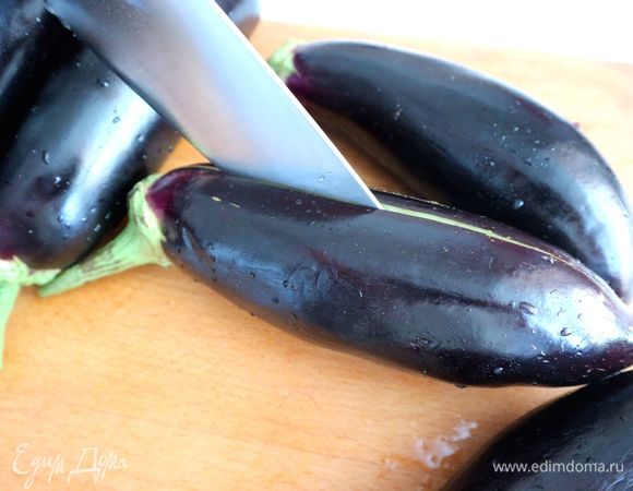 Сделать глубокий долевой надрез на каждом баклажане, стараясь не прорезать баклажан насквозь. Иногда баклажаны чистят «зеброй» — одна полоска с очищенной шкуркой, другая — без. Я не стала этого делать, чтобы сохранить овощной сок внутри баклажана.