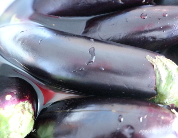 Положить баклажаны на 20–30 минут в подсоленную воду (1 ст. л. на 3,5-литровую кастрюлю). Промыть проточной водой, вытереть салфеткой. Поместить на решетку в разогретую духовку разрезами вверх, под решетку на всякий случай поставить противень. Запекать примерно 45–50 минут до мягкости баклажанов.