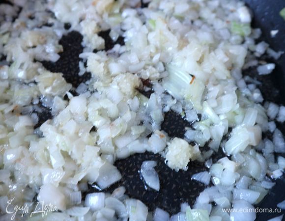 На сковороду поместить 4 ст. л. оливкового масла, поместить лук, обжарить до прозрачности, добавить чеснок, обжаривать с чесноком 1–2 минуты.