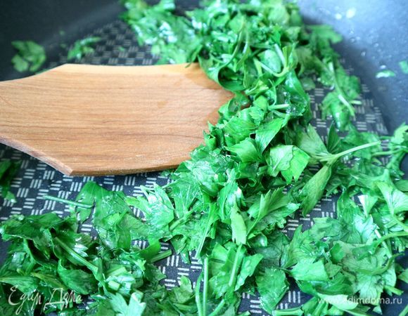 Зелень (листья) кинзы и петрушки нарезать, поместить на сковороду, в которую добавлено оливковое масло, обжарить в течение 1 минуты.