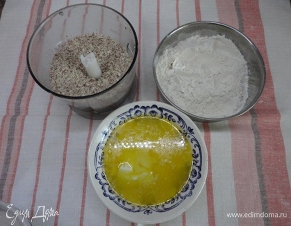 Сливочное масло растопить в микроволновой печи и дать остыть, миндаль подсушить на сухой сковороде и измельчить в мелкую крошку, муку соединить с разрыхлителем.