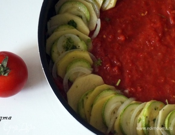 Приготовить соус: 5 помидоров измельчить в блендере или натереть на терке. Одну столовую ложку томатной пасты развести в небольшом количестве воды. Положить помидоры и томатную пасту в кастрюлю и довести до кипения. Добавить красный острый перец по вкусу. Взять большую круглую сковороду или форму для выпекания. На дно вылить томатный соус.